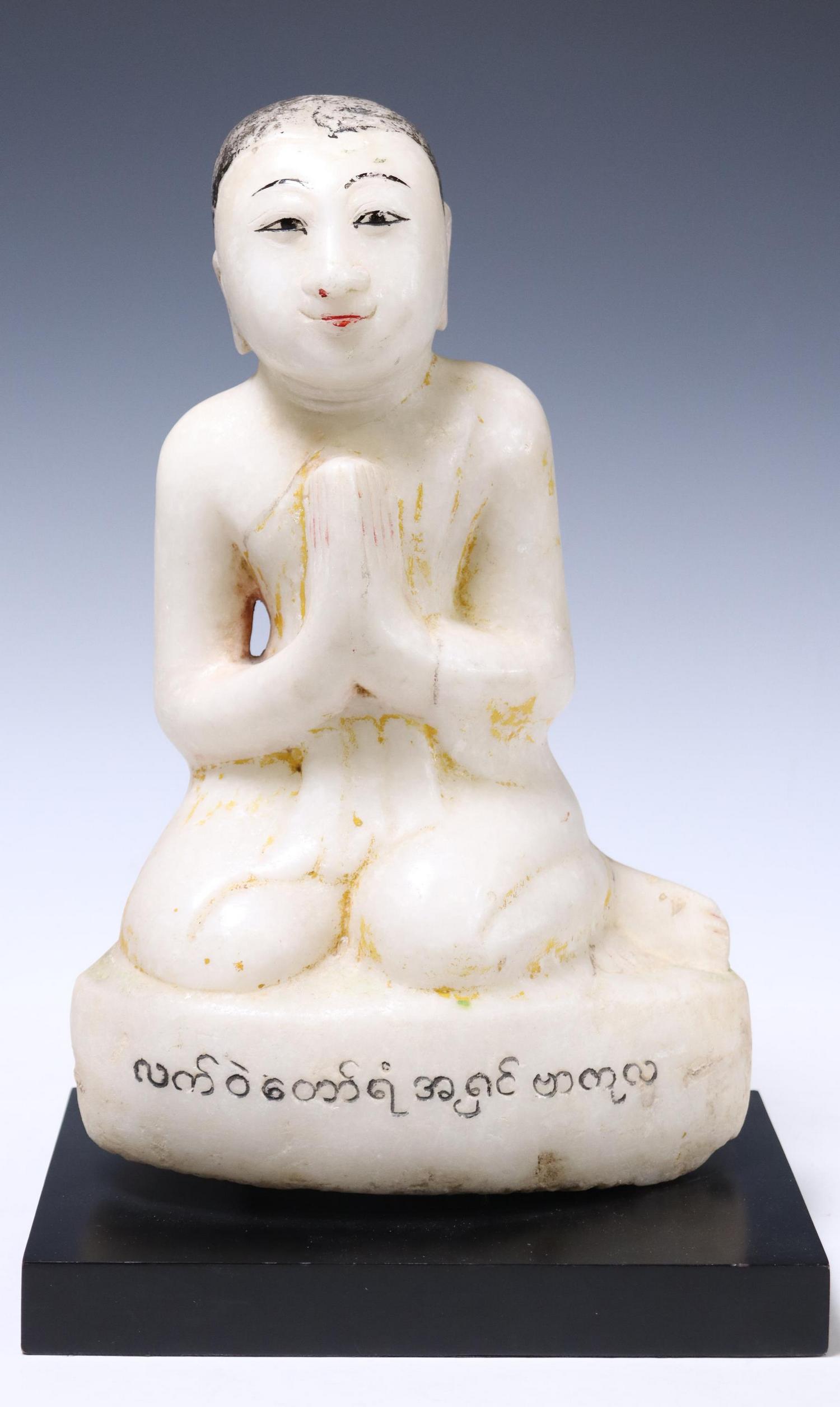 BURMESE CARVED STONE FIGURE BUDDHIST MONK: Carved stone figure of a Buddhist monk, Myanmar, depicted seated in Namaskara/ Anjali Mudra, plinth with inscription, remnants of polychrome pigments, on a later display base, approx 14.5"h, 9.5"w, 6.
