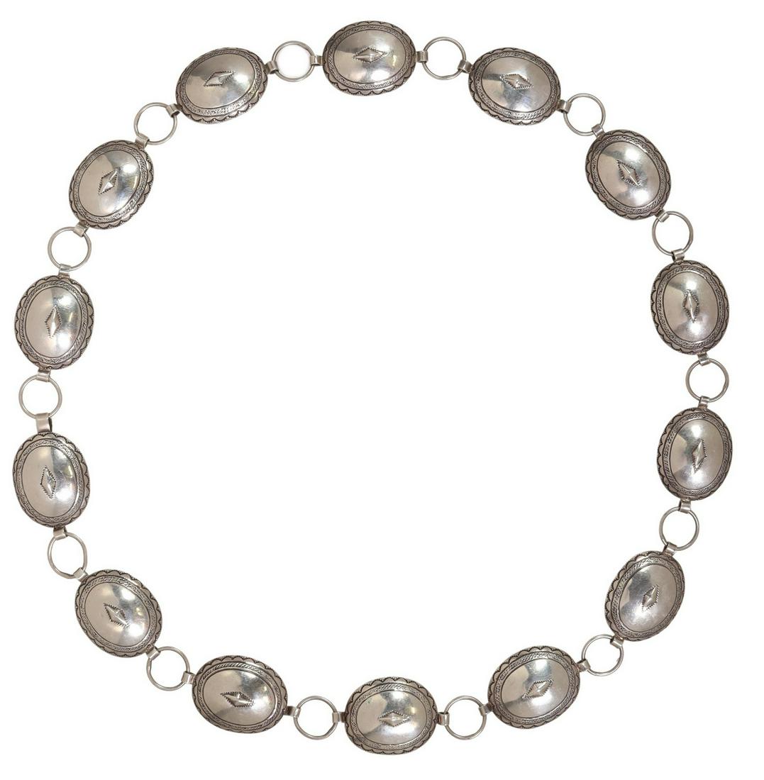 SOUTHWEST SILVER OVAL CONCHO BELT, 34"L: Southwest silver (content unknown) concho belt, oval buckle, with thirteen oval conchos, with geometric designs and running ornamentation stampwork, spaced by circular rings, unmarked, each concho: ap