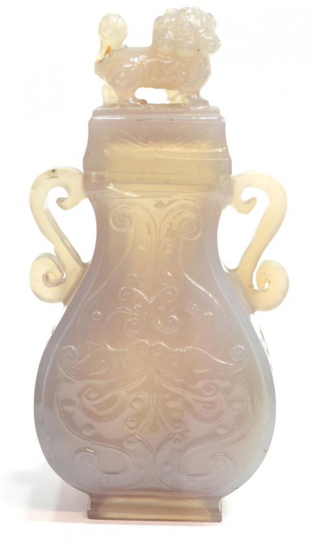 CHINESE CHALCEDONY URN WITH COVER: Chinese chalcedony urn with cover, the translucent honey-hued stone of pear-form with a square mouth and foot, the swelling sides carved in low relief with archaistic motifs and a pair of S-shaped han