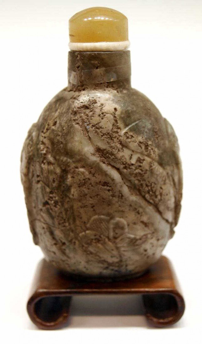 CHINESE CARVED MOTTLED STONE SNUFF BOTTLE: Chinese mottled stone snuff bottle, possibly dendritic chalcedony, of flattened ovoid shape carved in low relief with animal mask and mock loose ring handles framing a landscape with the details incor