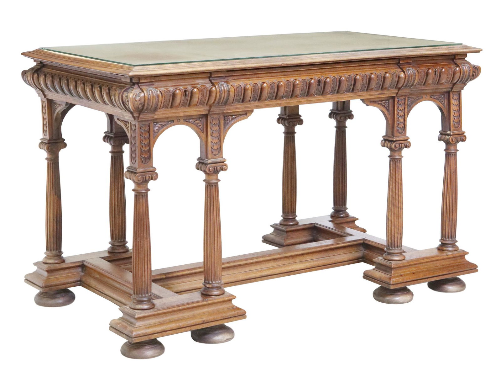 FRENCH HENRI II STYLE CARVED BUREAU PLAT DESK: French Henri II style bureau plat/ desk, 19th c., having glass top, over inset leather writing surface, gadrooned apron, fitted with three drawers, rising on fluted Corinthian column supports, joined 