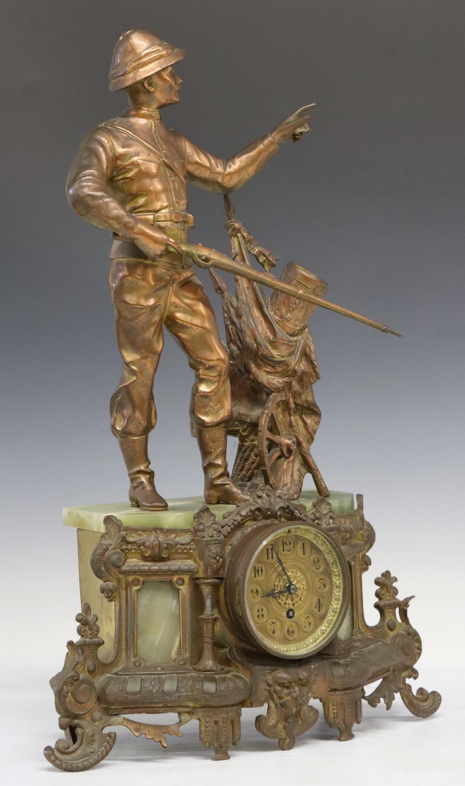 FRENCH METAL & ONYX SOLDIER MANTEL CLOCK: French patinated metal and onyx mantel clock, depicting solider with rifle, standing next to flags, a drum, and varied war accoutrements, glazed viewing panel, opening to gold-tone clock face, with Ar