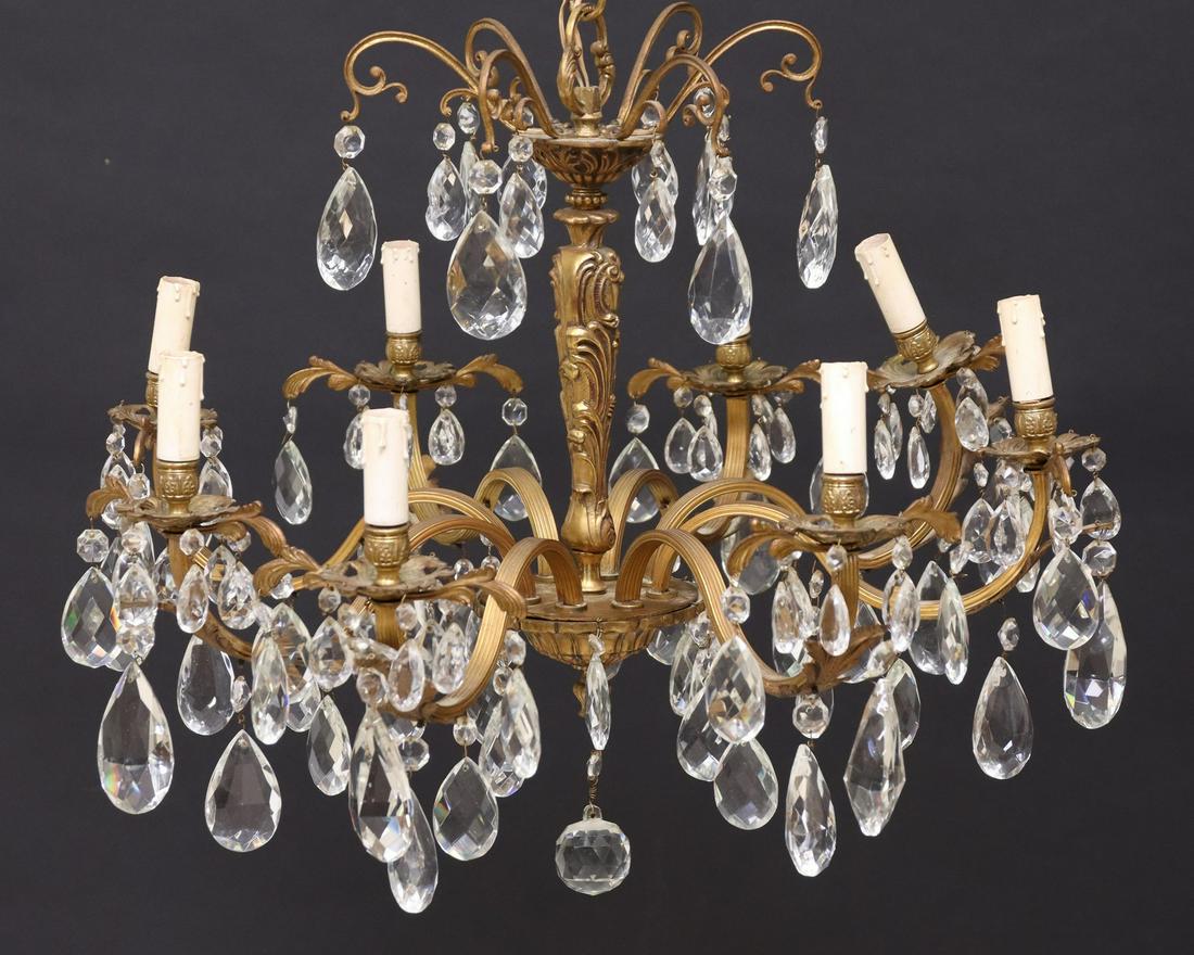 ITALIAN GILT METAL & CRYSTAL 8-LIGHT CHANDELIER: Italian gilt metal eight-light chandelier, 20th c., having baluster-form standard, issuing scrolling foliate arms, hung with crystal prisms, in need of wiring, approx 22"h, 25"diam Start Price: $100.0