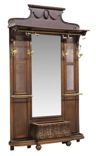 FRENCH WALNUT CANED & MIRRORED HALL TREE: French walnut hall tree, 19th c., having egg and dart and swag cornice, caned top shelf and side panels, centering beveled mirror plate, nine gilt metal hooks, all over foliate carved jardiniere, flan