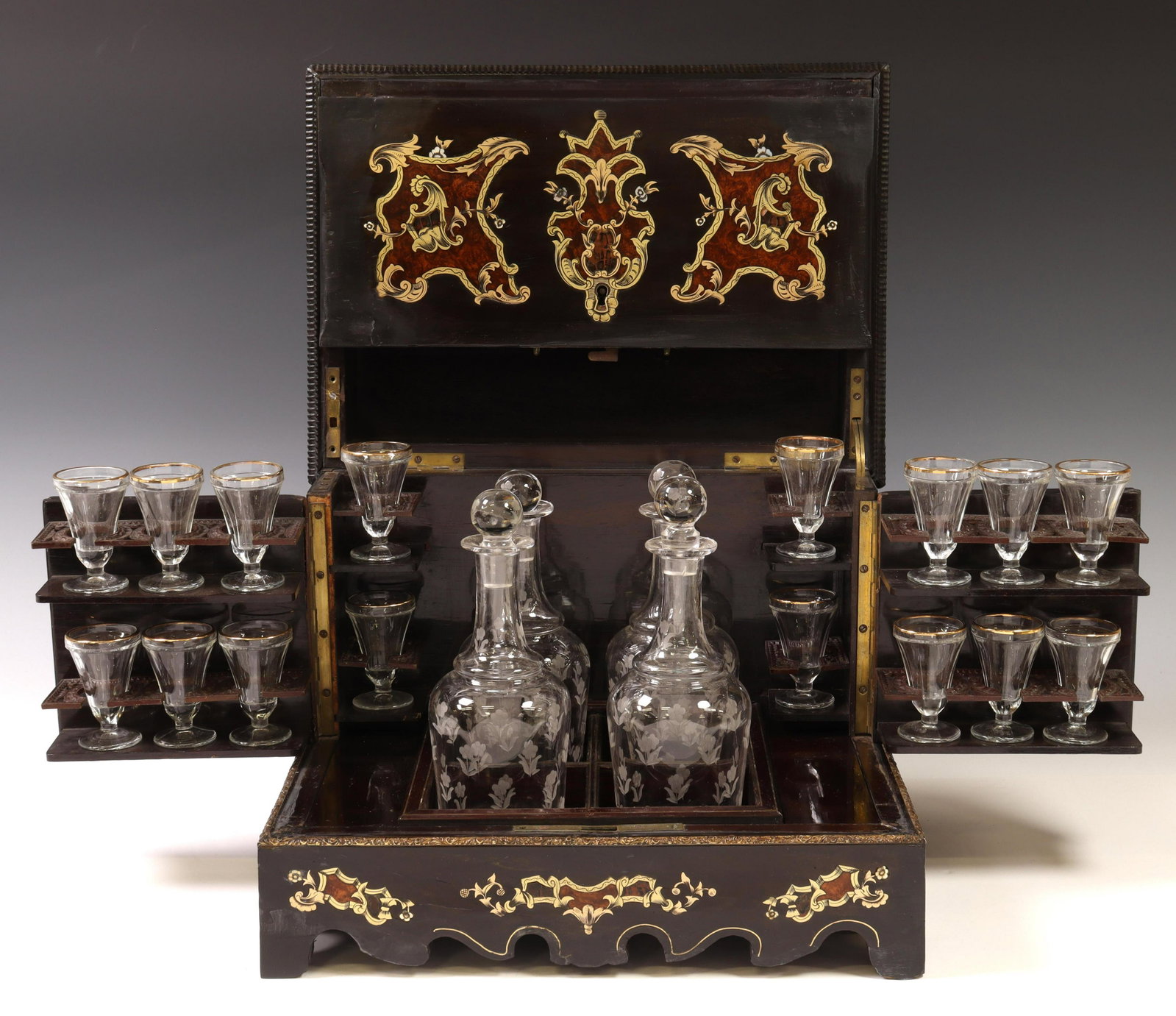 FRENCH NAPOLEON III PERIOD INLAID CAVE A LIQUEUR: French Napoleon III period cave a liqueur, late 19th c., ebonized case with gilt metal and burlwood inlay, depicting scrolled foliates and floral motifs, opening to fitted interior with (four) etched 