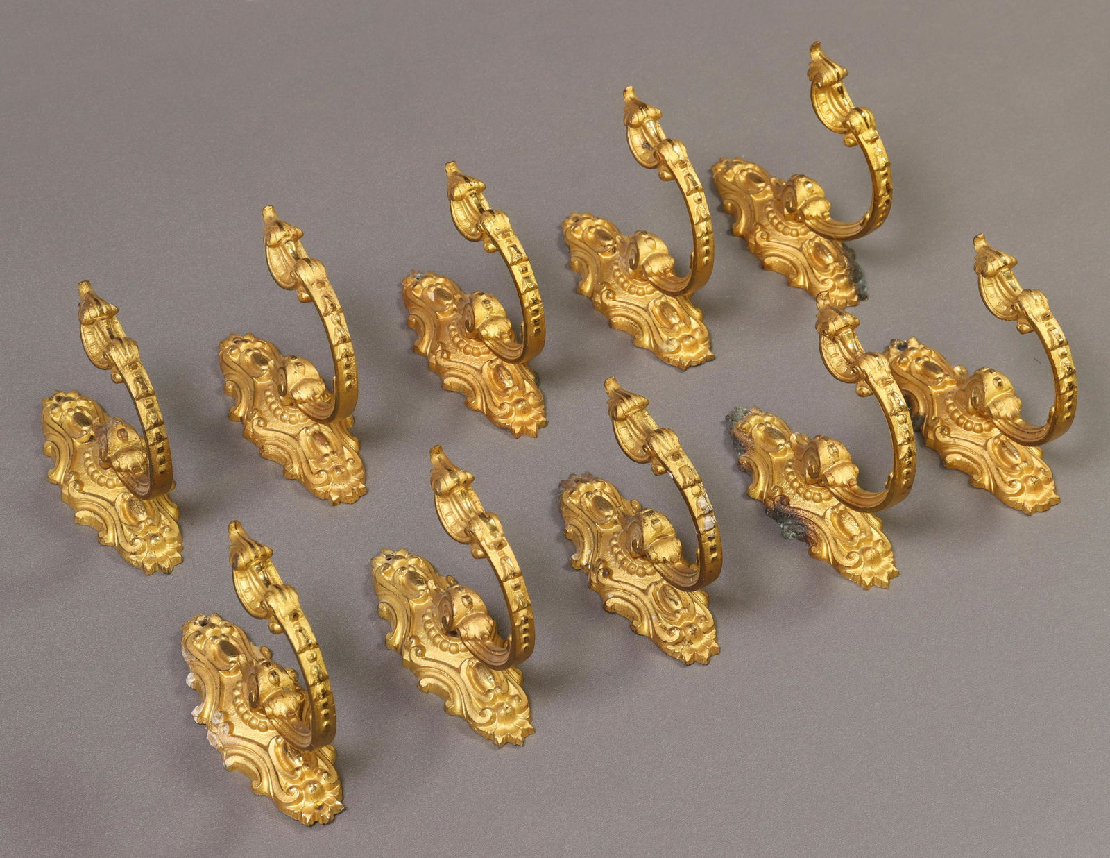 (10) ARCHITECTURAL BRONZE DORE WALL-MOUNTED HOOKS: (lot of 10) Gilt bronze wall-mounted hooks, approx 3.75"h, 1.5"w; 3lbs total Start Price: $150.00