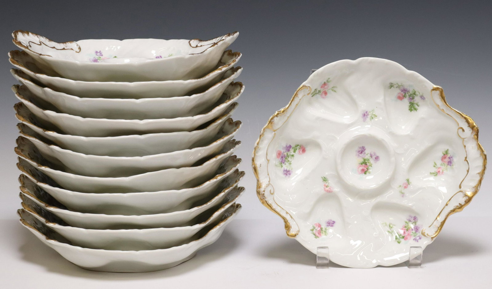 (12) FRENCH LIMOGES MANDAVY MAVALEIX OYSTER PLATES: (lot of 12) French Limoges porcelain oyster plates, Mandavy de Mavaleix, having parcel gilt trim and floral motifs, scalloped-shaped wells, maker's mark underfoot, some overall gilt loss, approx 9.5"l