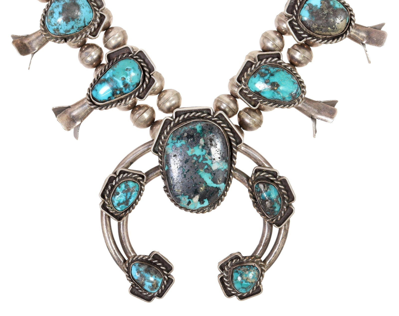 NATIVE AMERICAN TURQUOISE SQUASH BLOSSOM NECKLACE: Native American silver (content unknown) squash blossom necklace, likely Navajo, twelve blossoms each set with a turquoise cabochon, central naja pendant with five stones all bezel set in a rope twist