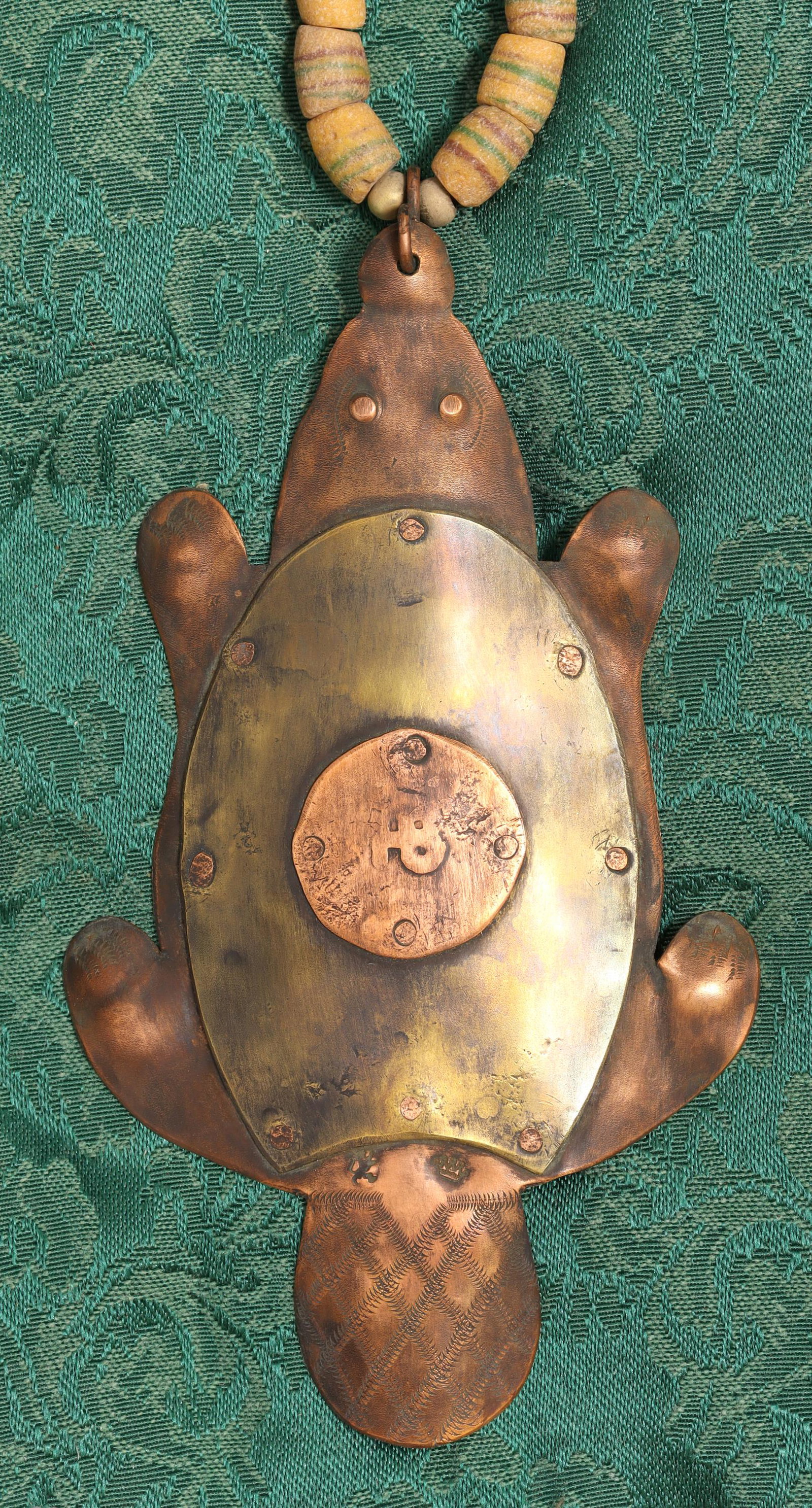 HUDSON BAY FUR TRADE BEAD NECKLACE & BEAVER EFFIGY: Hudson Bay Company fur trade beaded necklace with copper and brass beaver pendant stamped at the center with worn "HB", most beads with red and green circular decoration, the necklace approx. 33"l, th