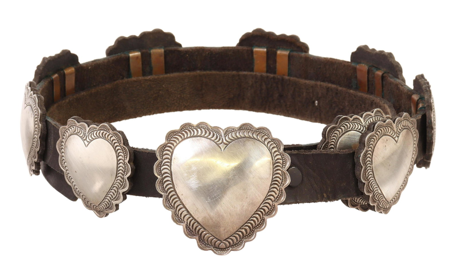 NATIVE AMERICAN STERLING SILVER HEART CONCHO BELT: Native American sterling silver concho belt, stamped D, possibly John Delvin (Navajo, 20th c.), heart-shaped stampwork buckle, with ten matched smaller conchos, on black leather belt, buckle: approx 2