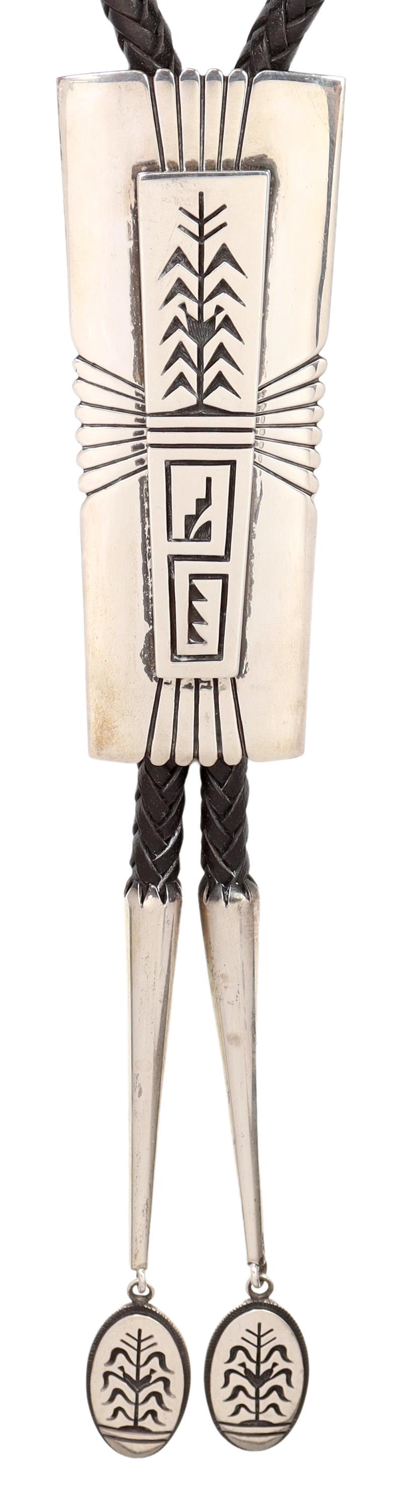 RAMON DALANGYAWMA JR (B.1954) SILVER OVERLAY BOLO: Native American sterling silver bolo tie, Ramon Albert Dalangyawma Jr. (Hopi/ Navajo, b.1954), large ornament with silver overlay cornstalk design, matching bolo tips, braided black leather cord, bolo