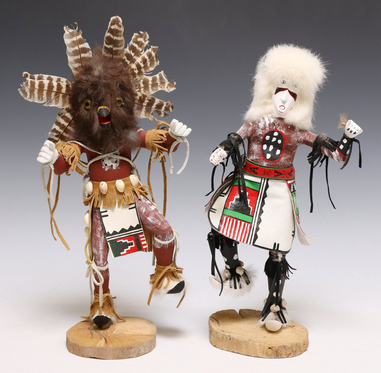 (2) SHERRY BEGAY NAVAJO POLYCHROME KACHINA DOLLS: (lot of 2) Native American carved Kachina dolls, Sherry Begay, Navajo, 20th c., both polychrome painted and embellished with shells, fur, and feathers, rising on wood slice base, signed underfoot, inc