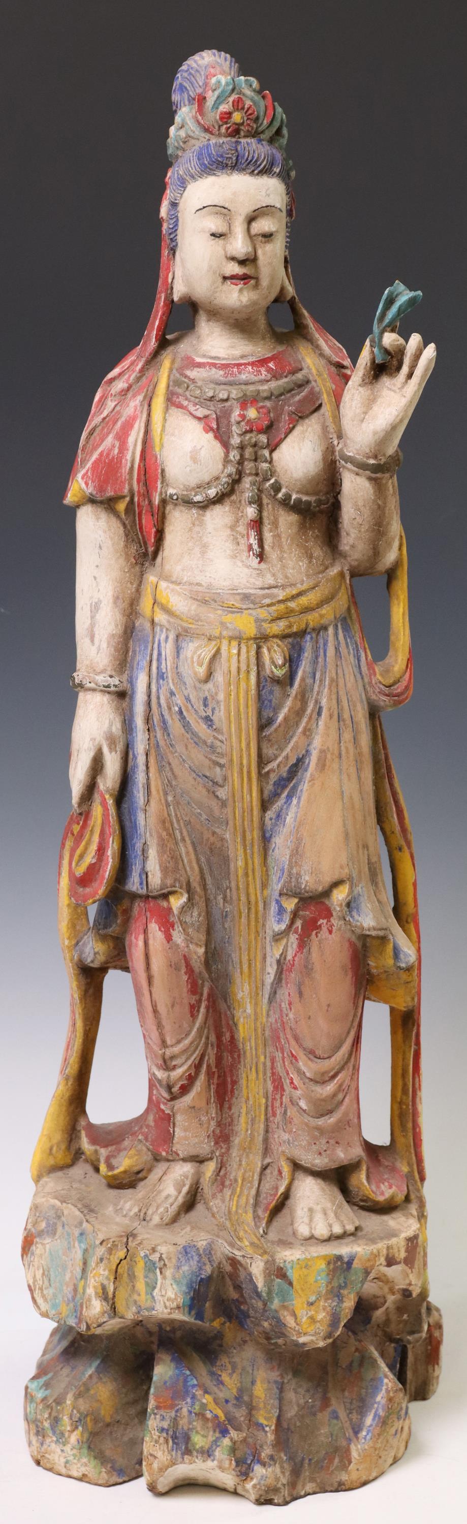CHINESE CARVED POLYCHROME WOOD STANDING GUANYIN: Chinese carved and polychrome painted wood figure of a standing Guanyin, wearing floral crown, open robes, rising on integral naturalistic base, approx 25"h, 7 5/8"w, 7.25"d, 7.75lbs **Provenance: Fro