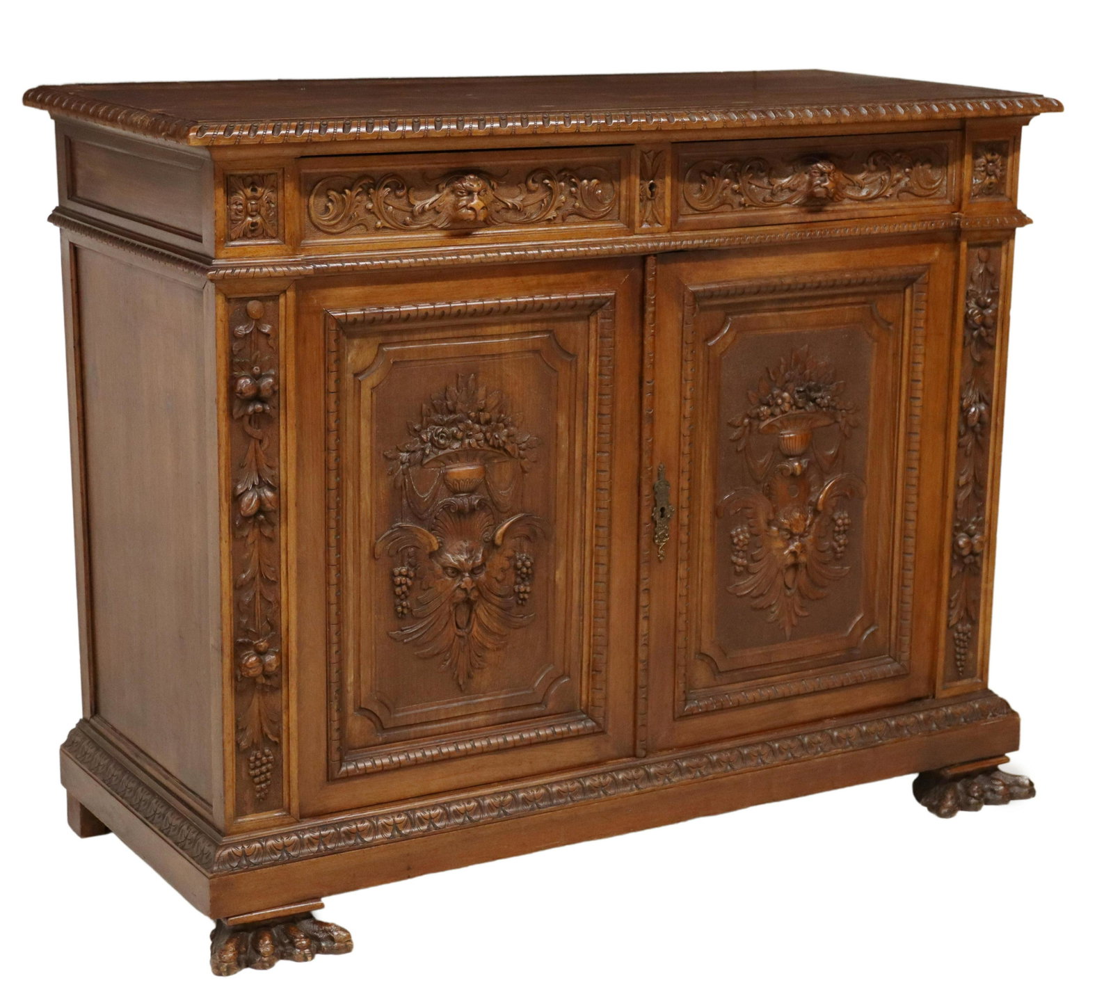 ITALIAN RENAISSANCE REVIVAL CARVED SIDEBOARD: Italian Renaissance Revival carved walnut sideboard, early 20th c., having two beast mask drawers, over two cabinets, flanked by carved fruits, rising on paw feet, approx 42.75"h, 54.5"w, 24.25"d Star