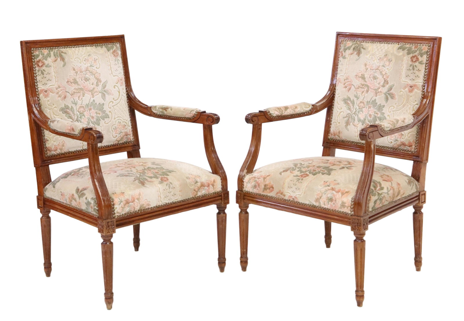 (2) LOUIS XVI STYLE FLORAL UPHOLSTERED FAUTEUILS: (pair) Louis XVI style armchairs, 20th c., in a floral pattern upholstery, with nailhead trim, scrolled handholds, rising on fluted and tapered legs, ending on blunt arrow feet, approx 35 1/8"h, 22.25