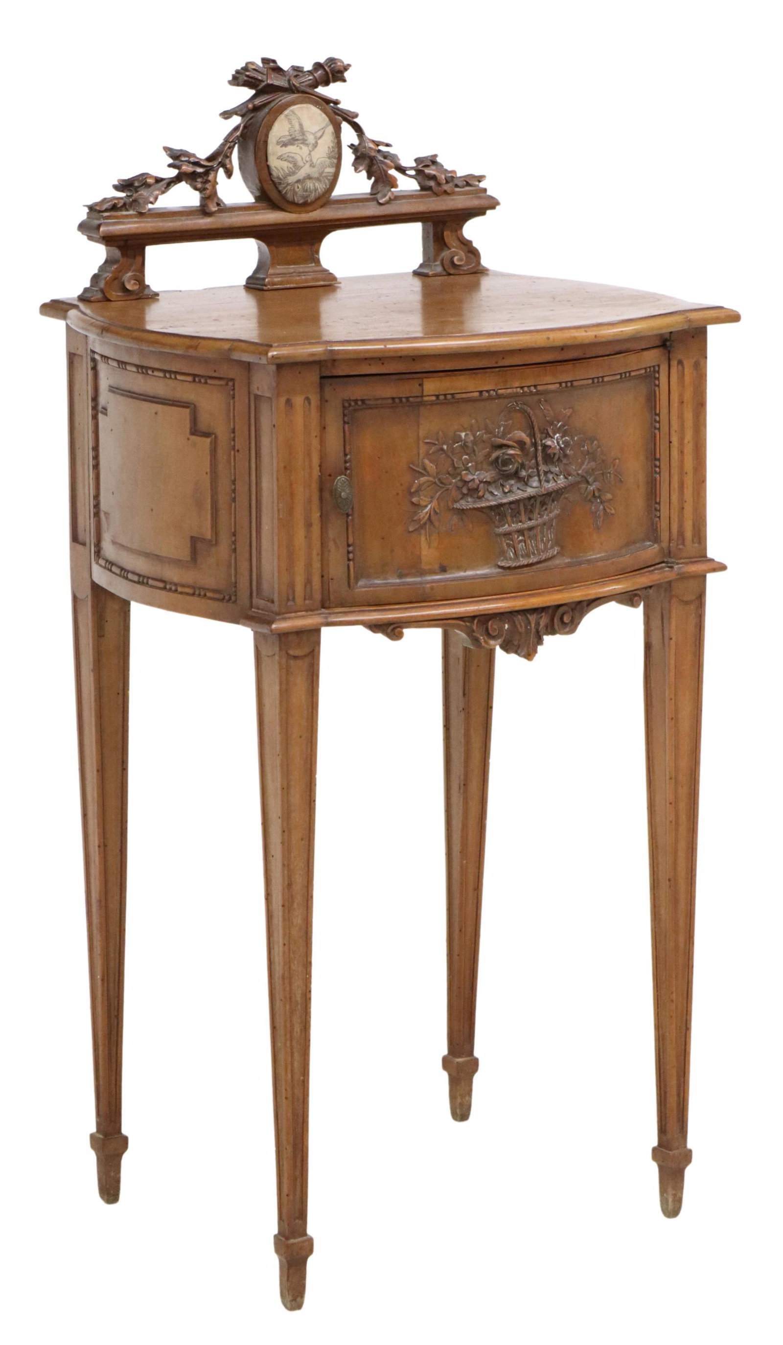 FRENCH LOUIS XVI STYLE CARVED BEDSIDE CABINET: French Louis XVI style bedside cabinet, 19th c., having torch and quiver crest, over cabinet door with carved foliated basket, opening to interior with marble bottom, rising on tapered legs, approx 37