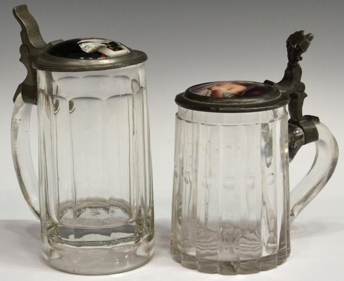 (2) ANTIQUE GERMAN STEINS, PORTRAIT OF BEAUTIES: (lot of 2) German glass steins, each pewter lid set with a porcelain portrait plaque: (1) showing a young lady peaking through shear soft magenta curtains as her dress slips off her shoulder, with abs