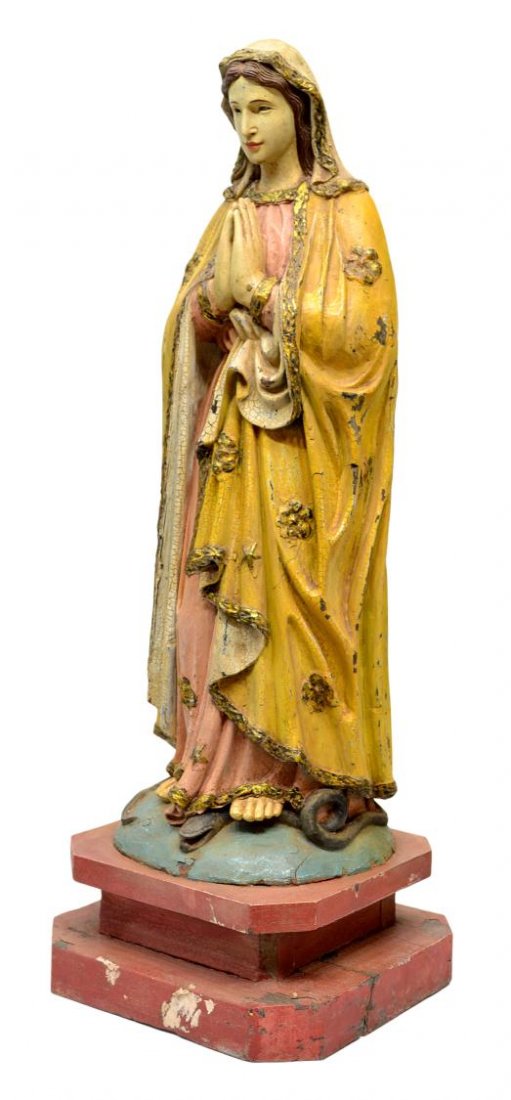 ANTIQUE FRENCH COLONIAL CARVED RELIGIOIUS STATUE: Antique French Colonial religious wood statue, 19th c., the Virgin Mary, carved with with a serene face, her hands in prayer, parcel gilt yellow robe drape over a soft pink dress, standing upon the se