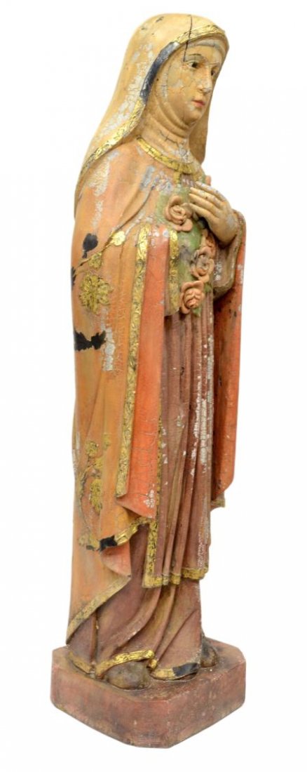 LARGE ANTIQUE RELIGIOUS COLONIAL CARVED SAINT: French Colonial carved wood religious statue, 19th c., depicting a saint, glass faced eyes, robe with parcel gilt trim and floral detail, roses in relief upon the chest, rising on small square stand,
