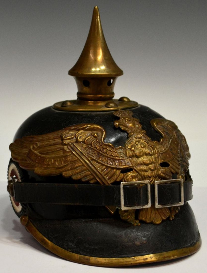 GERMAN PICKELHAUBE SPIKE HELMET, PRUSSIA: German pickelhaube helmet fitted with metal front plate depicting the Prussian coat of arms affixed with later hardware, polished leather body, metal rimmed visor, missing neck guard and metal tail, c