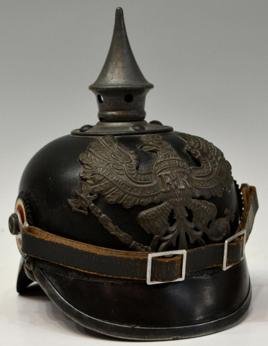 GERMAN PICKELHAUBE SPIKE HELMET, PRUSSIA: German pickelhaube helmet fitted with metal front plate depicting the Prussian coat of arms, polished leather body, metal rimmed visor, neck guard, chin strap, red and white kokarden, interior leather