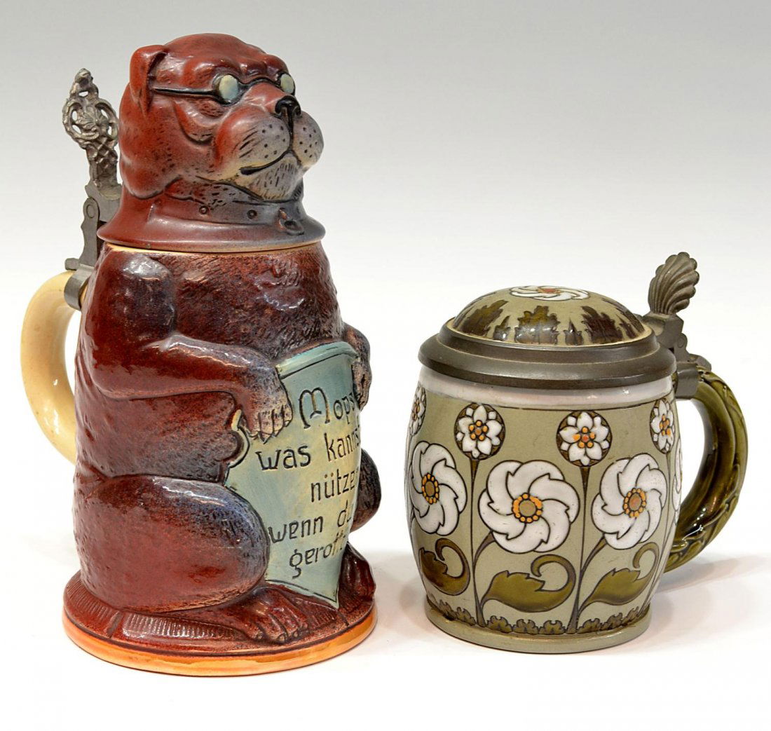 GERMAN FIGURAL 'DOG' CHARACTER BEER STEIN: (lot of 2) German steins: (1) figural character stein, dog with glasses, holding a plaque reading 'Mops Was Kannst Du Nutzen Wenn Du Nicht Gerollt Bist', crazing to handle, approx 8"h; (1) small Ville