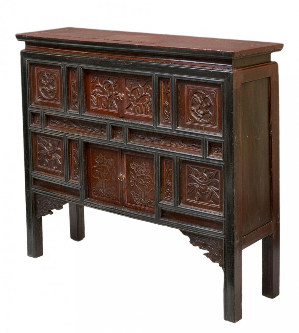 ASIAN HAND CARVED RED & BLACK LACQUER CABINET: Asian hand carved lacquered red and black cabinet, a rectangular top surmounting the slightly tapered case set with foliate carved panels, two sliding doors open to storage, squared supports with fron