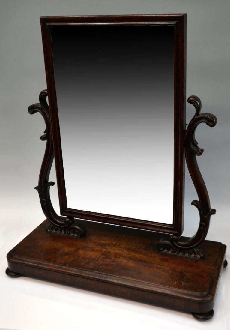 LARGE ANTIQUE CONTINENTAL MAHOGANY DRESSING MIRROR: Large Continental mahogany dressing table mirror, 19th c., with adjustable mirror held by two foliated scrolled uprights hold the rectangular swing mirror, large base with bun feet, with age some loss
