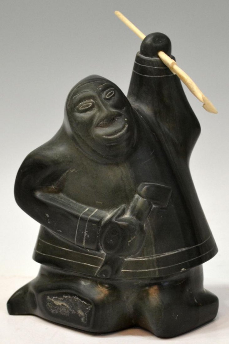 INUIT FIGURAL STONE CARVING, SIGNED: Inuit stone carving of a kneeling figure with axe and carved bone spear, signed on base as pictured, retaining tag 'Original Eskimo Art', numbered, 7.75"h, 6"l, 7.5lbs **Provenance: the estate of Maxw