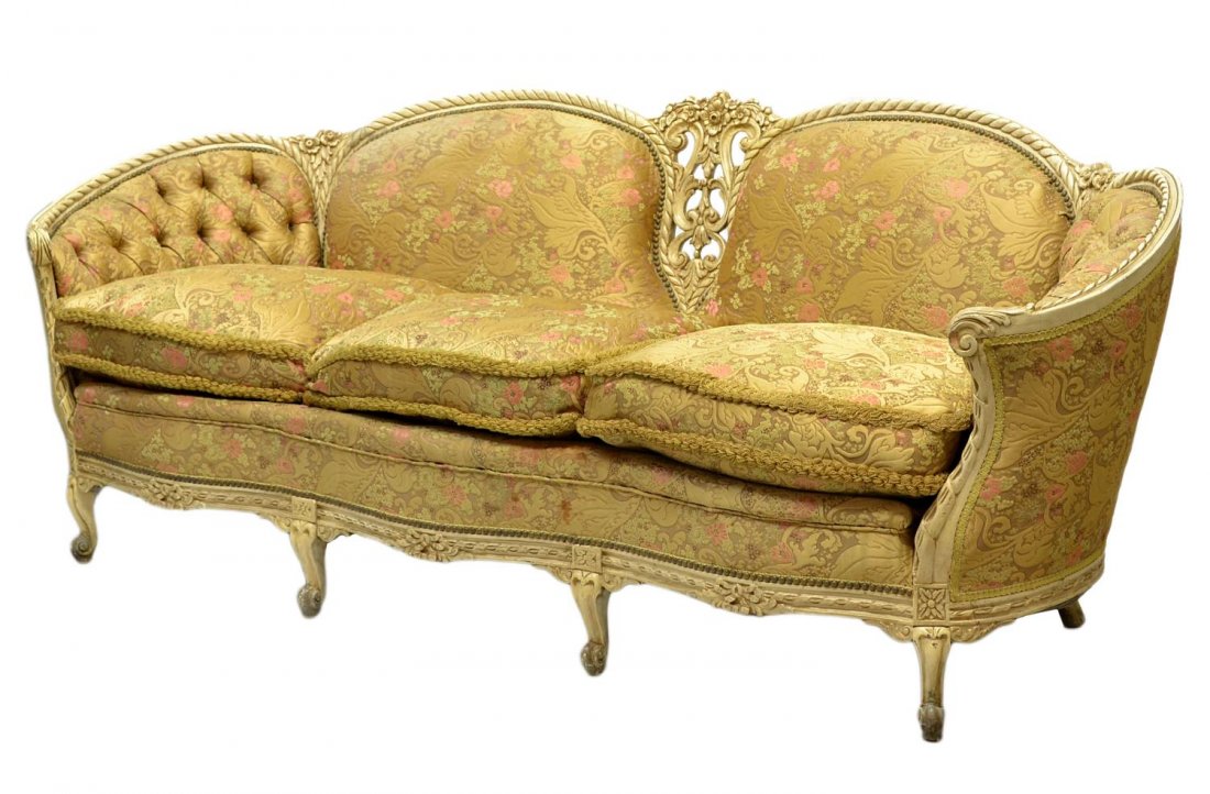FINE LOUIS XV STYLE CARVED & PAINTED TUFTED SOFA: Louis XV style sofa, c. 1920, having an ornately pierce carved central splat, dual back rest and tufted curving arms framed by a rope carved frame in cream paint, three loose cushions raised on shore 