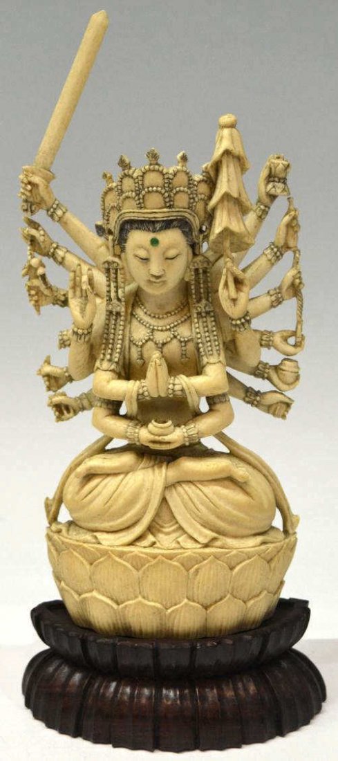 CHINESE CARVED IVORY MULTI ARM DEITY ON BASE: **This item will not be shipped internationally** A Chinese carved ivory deity seated in the lotus position upon a raised lotus pedestal, adorned in elaborate jewelry and headdress with green bindi, e