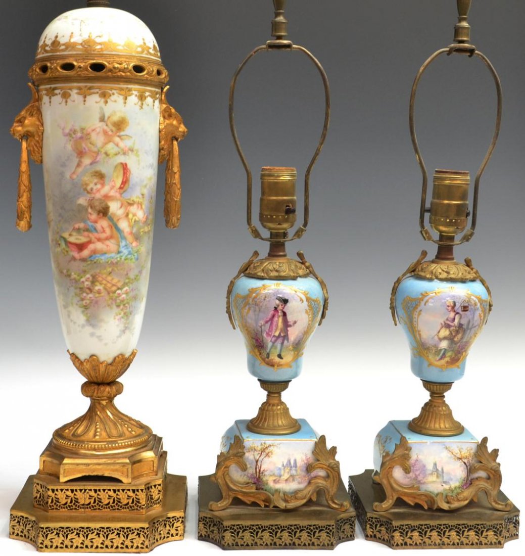 (3) PORCELAIN LAMPS, PAIR BOUDOIR & SEVRES STYLE: (lot of 3) Figural decorated porcelain lamps: (1) Sevres style porcelain lamp decorated with musical putti, a spurious Sevres mark underfoot, set on foliate reticulated stepped base, overall: 36,5"h, 