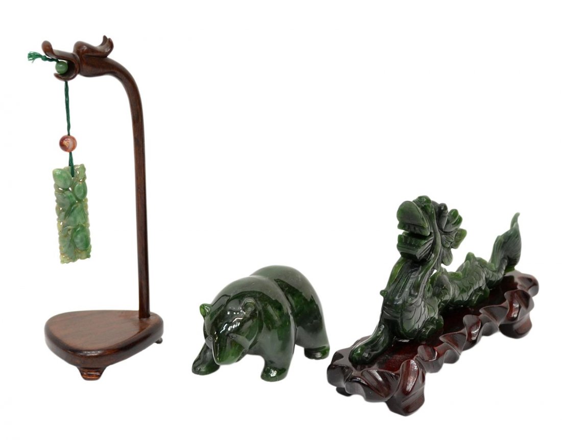 (3) CHINESE JADE CARVINGS, DRAGON, PLAQUE, BEAR: (lot of 3) Chinese jade carvings: (1) pierced plaque of rectangular form, hung from a wood stand with figural dragon head terminal, plaque: 1.75"l, stand: 6.25"h; (1) dark green jade dragon fitted on