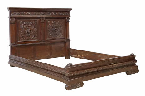 ITALIAN RENAISSANCE REVIVAL CARVED WALNUT BED: Italian Renaissance Revival carved walnut bed, early 20th c., having paneled headboard with central mask motifs, flanked by columnar corner posts and foliate scrollwork, molded rails and baseboard, ri