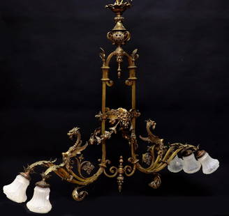 BRASS FIGURAL DRAGON 6-LIGHT BILLIARDS CHANDELIER: Figural brass six-light chandelier, 20th c., having pierced urn-form finial, over architectural standard, flanked by winged dragons atop scrolled arms, in need of wiring, one shade with crack, finish