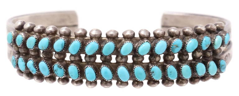 NATIVE AMERICAN SILVER & TURQUOISE CUFF BRACELET: Native American silver (content unknown) two-prong cuff bracelet, with inset petit point turquoise, beaded border, stamp work detail, approx .50"w, interior: approx 5.25"l, gap: approx 7/8"w, 23.7 Sta