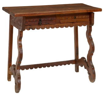 SPANISH BAROQUE STYLE CARVED OAK WRITING DESK: Spanish Baroque style carved oak writing desk, late 19th c., rectangular top over two drawers, rising on ox yoke supports, split to wood at right side support, lacking a pull to one side, drawers tigh