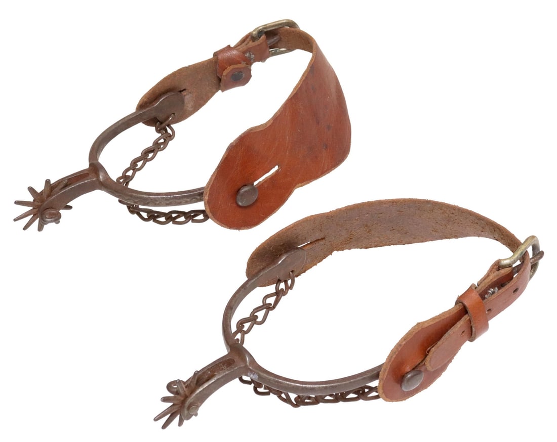 (PAIR) COWBOY SPURS, AUGUST BUERMANN: (pair) Cowboy Spurs, early August Buermann iron pair with heel chains, 10 point 1.25" rowels, intertwined oval decoration, slot for jingle bobs, later leathers, for shipping total of both .50lb Start
