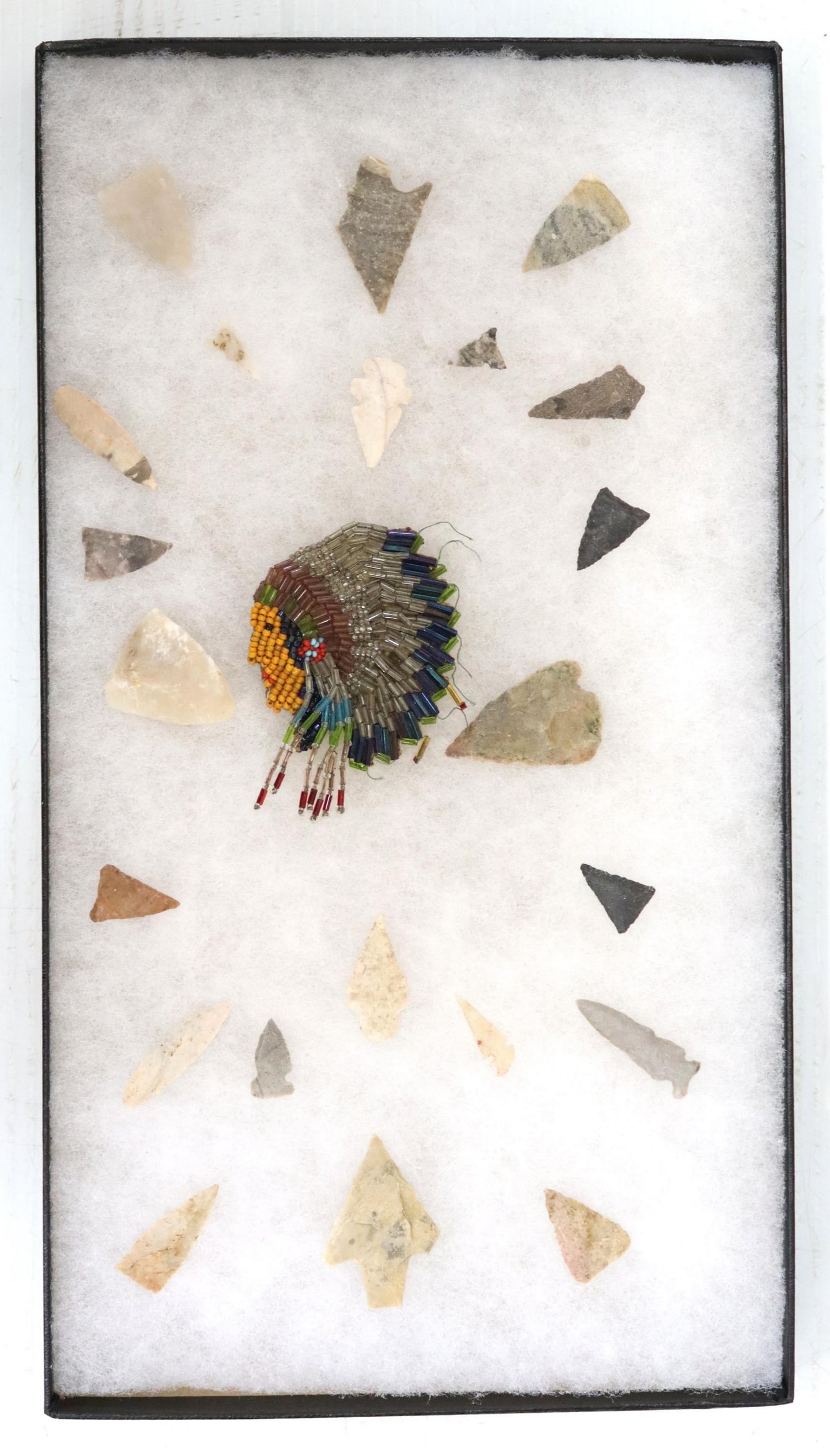 (23) STONE SPEAR POINTS & ARROWHEADS: (lot of 23) Arrowheads and spear points, with (1) beaded hide applique depicting a Native American, all housed in Riker display box, largest arrowhead: approx 1.75"l, 1.25"w, box: approx 1"h, 14.5"l, 