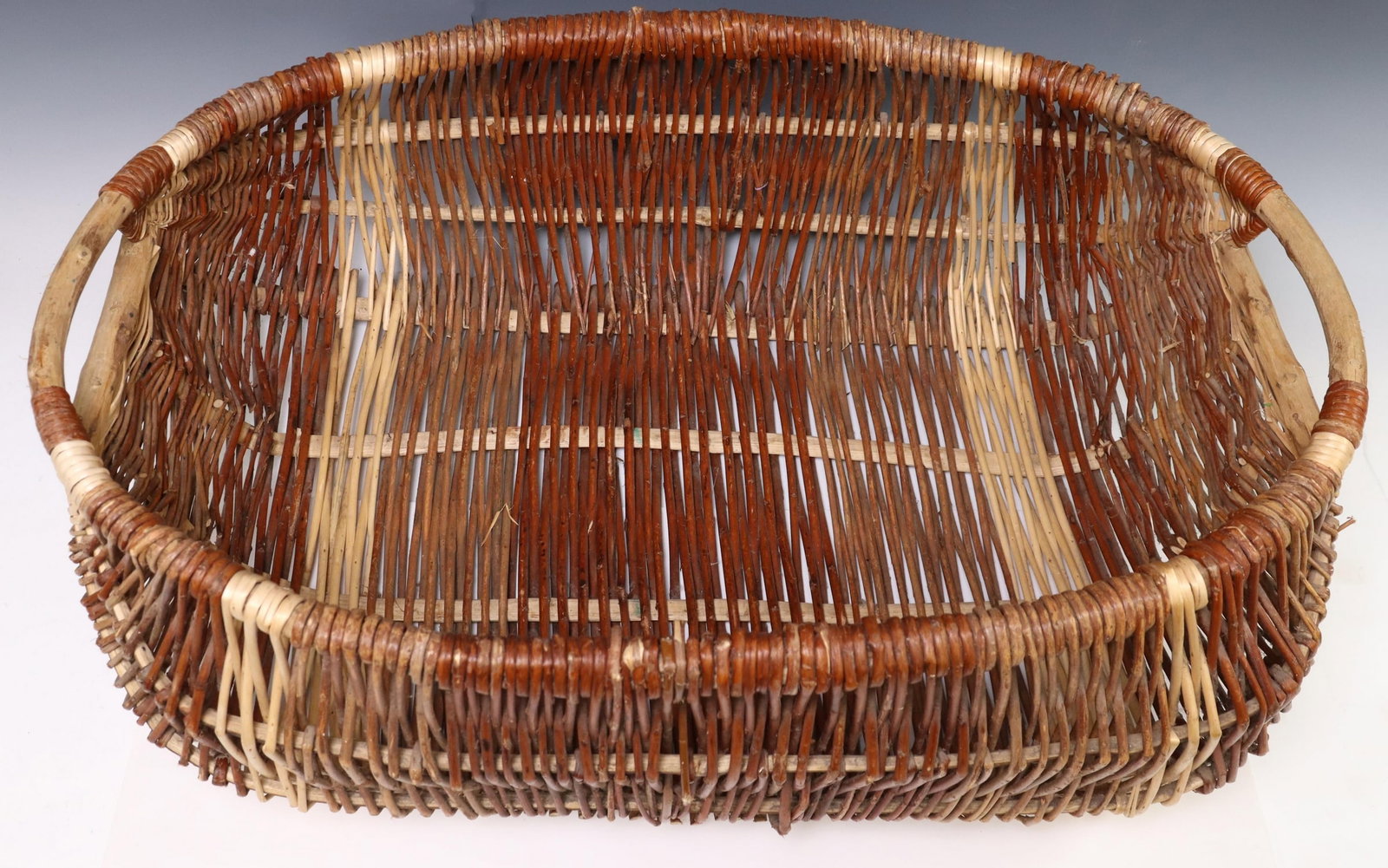 LARGE PROVINCIAL WOVEN WILLOW HANDLED BASKET: Large Provincial woven willow basket, approx 11.5"h, 31"l, 21"w, 6.75lbs Start Price: $60.00