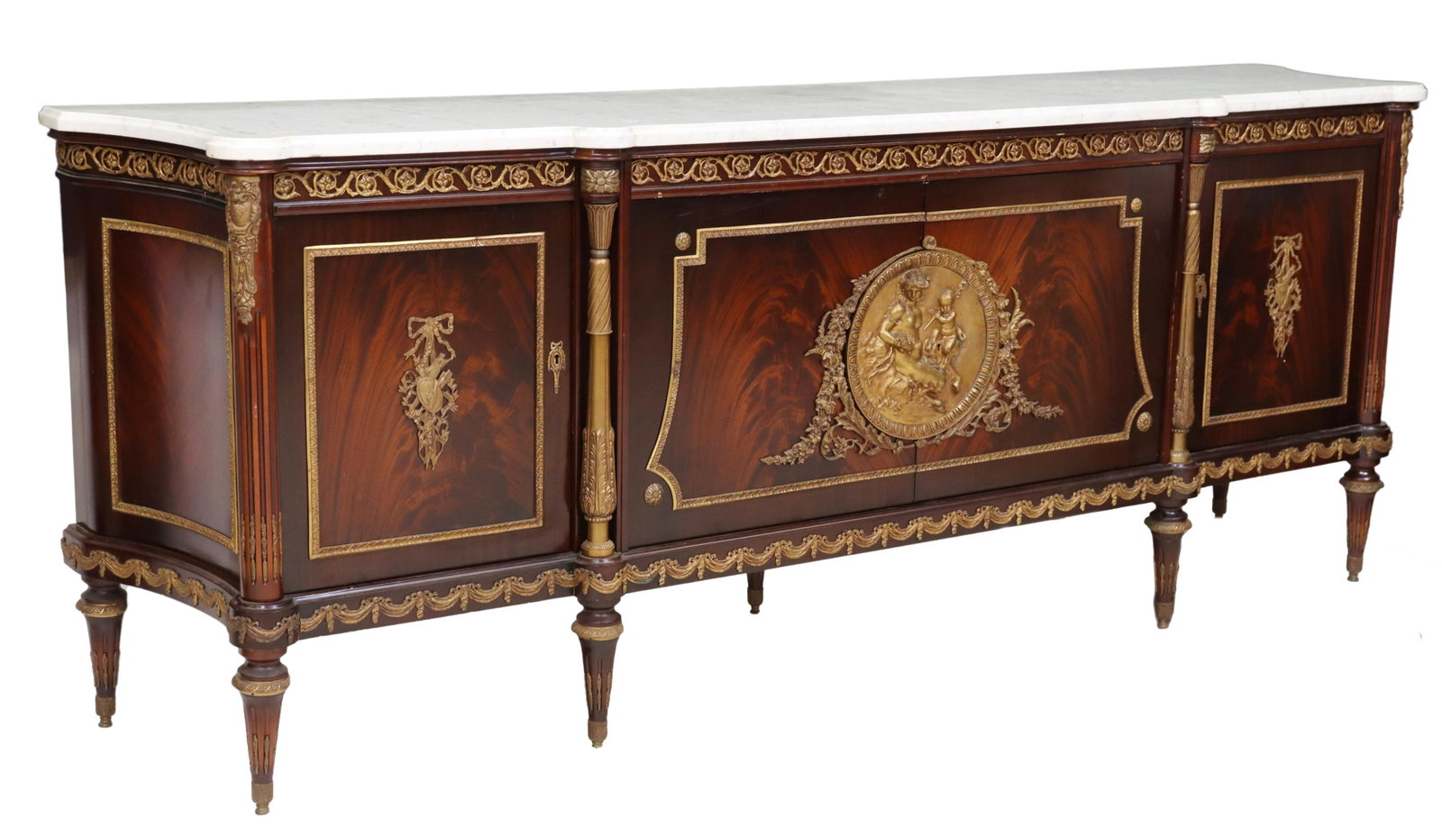 LOUIS XVI STYLE MARBLE-TOP MAHOGANY SIDEBOARD: French Louis XVI style mahogany sideboard, late 20th c., the shaped white marble top over two center doors having a large circular brass depiction of a satyress and cherub, flanking brass columns and 