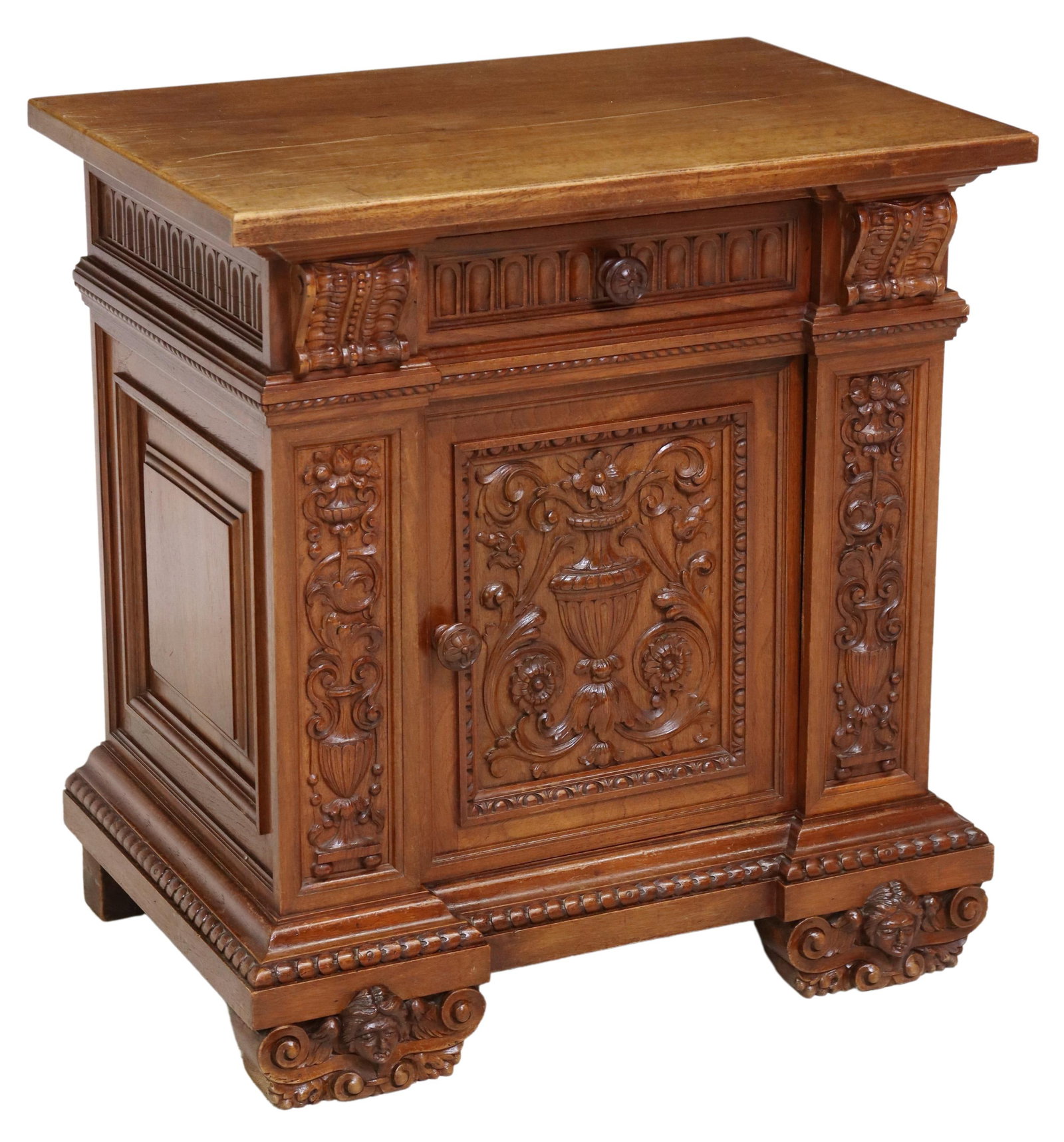 ITALIAN RENAISSANCE REVIVAL CARVED WALNUT CABINET: Italian Renaissance Revival carved walnut cabinet, early 20th c., having single drawer, over cabinet door, revealing shelved interior, carved with floral urn and foliate scrollwork, rising on figural 