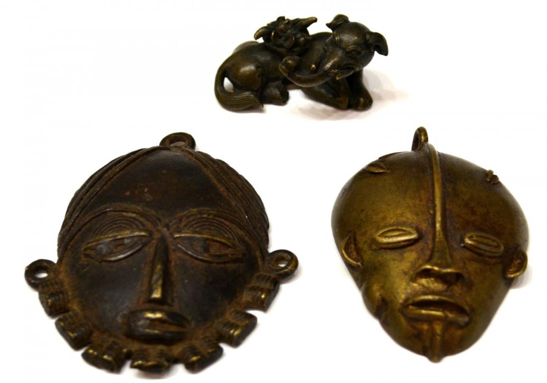 (3) BRONZES, AFRICAN PENDANTS & MYTHICAL CREATURE: (lot of 3) Two African bronze Benin style mask pendants, largest: 3"h; together with (1) small bronze mythical figure, the recumbent figure with tail and trunk nose, possibly Baku, loss to one tusk, 1