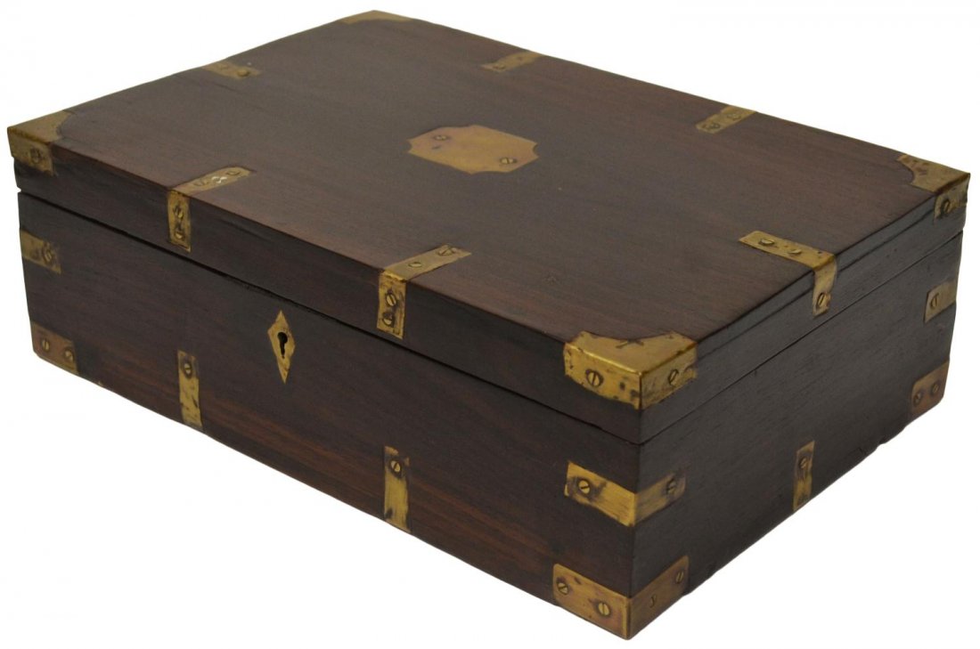 BRITISH COLONIAL BRASS BOUND ROSEWOOD BOX: Small British Colonial brass bound box, c. 1900, the rosewood case with central brass cartouche, opening to a fitted interior, refinished, 4.75"h, 14.5"l, 9.5"d, 6.5lbs Start Price: $80.00