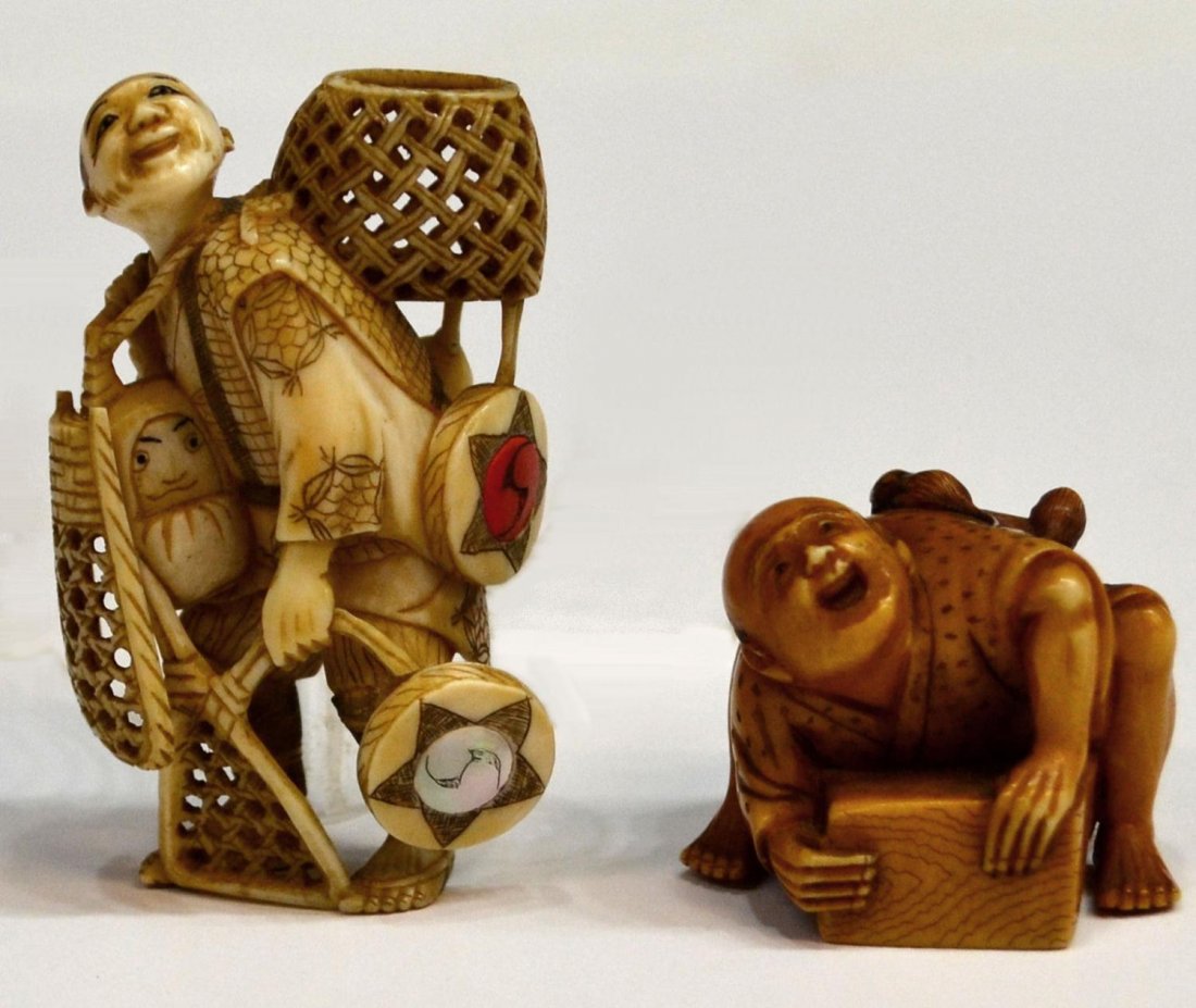 (2) JAPANESE IVORY FIGURAL NETSUKE: **This lot will not be shipped Internationally**(lot of 2) Japanese ivory figural netsuke, each with incised and dark pigment accents: (1) walking vendor with various types of baskets, drums and Darum