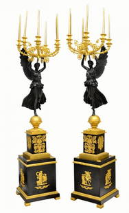 EMPIRE STYLE WINGED MAIDEN BRONZE TORCHIERES, 70"H: (pair) Empire style gilt and patinated bronze six-light torchieres, each in the form of a winged maiden supporting a scrolled foliate candelabrum, raised on a square black metal pedestal with figural