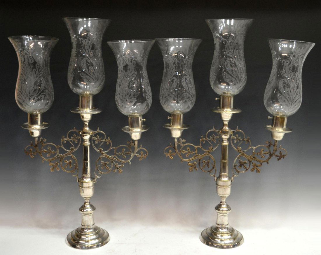 (2) IMPRESSIVE SILVER PLATE HURRICANE CANDELABRAS: (pair) Ornate Continental three-light silver plate candelabra, Madrid, Spain, each having three glass hurricanes with foliated detail, pierced foliated branches join the central standard rising on a s