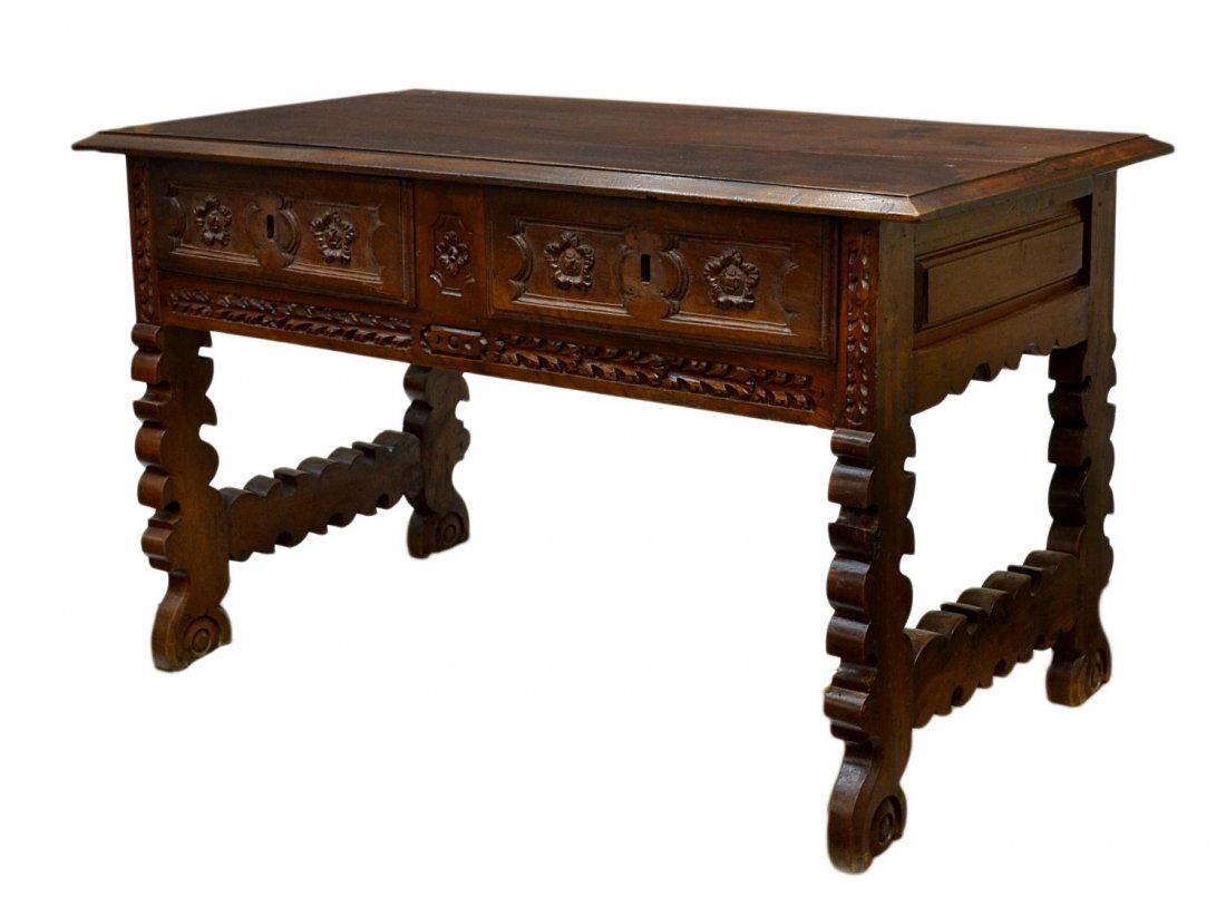 ANTIQUE SPANISH BAROQUE STYLE CARVED WALNUT DESK: Spanish Baroque style walnut desk, early 19th c., pine secondary wood, the rectangular top having molded borders and old patch restorations as pictured, a pair of frieze drawers with carved floral hea
