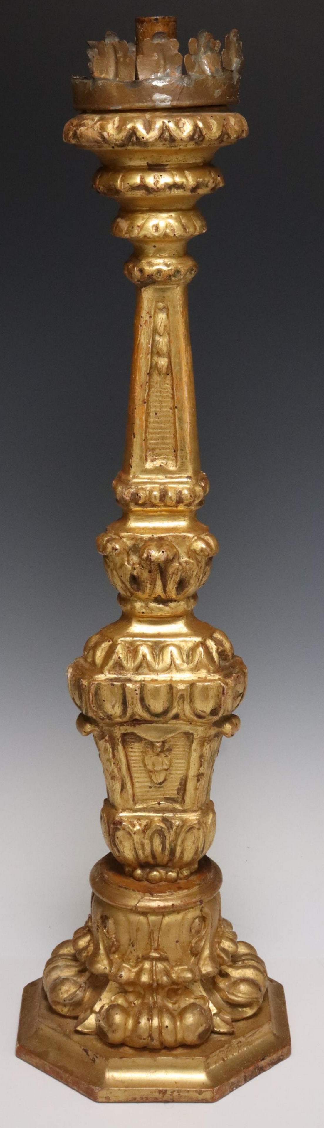 ITALIAN BAROQUE STYLE GILTWOOD CANDLESTICK: Italian Baroque style giltwood candlestick, early 20th c., having scalloped iron bobeche, over turned standard with gadrooned and scrolled foliate molding, rising on octagonal base, some loss to iron 