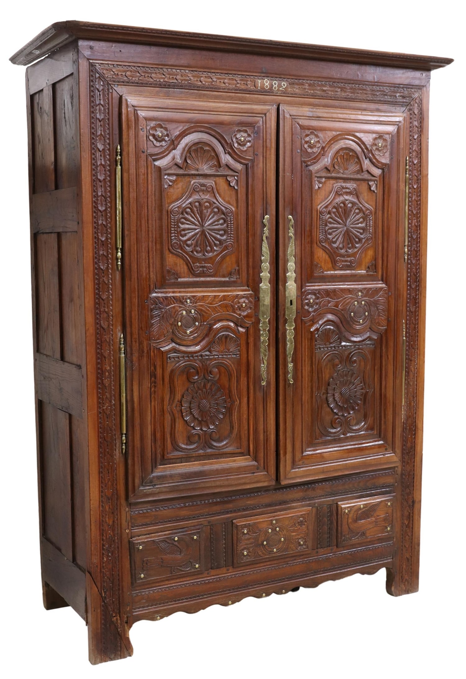 FRENCH PROVINCIAL HEAVILY CARVED OAK ARMOIRE, 1882: French Provincial carved oak armoire, late 19th c., stepped cornice, over crest with applied gilt metal medallions reading 1882, dual cabinet doors carved with scrollwork and floral motifs, escutcheon